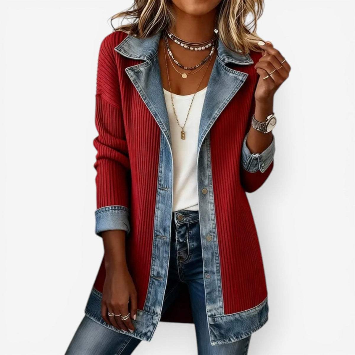 Red ribbed sweater with denim accents worn by a person on a white background